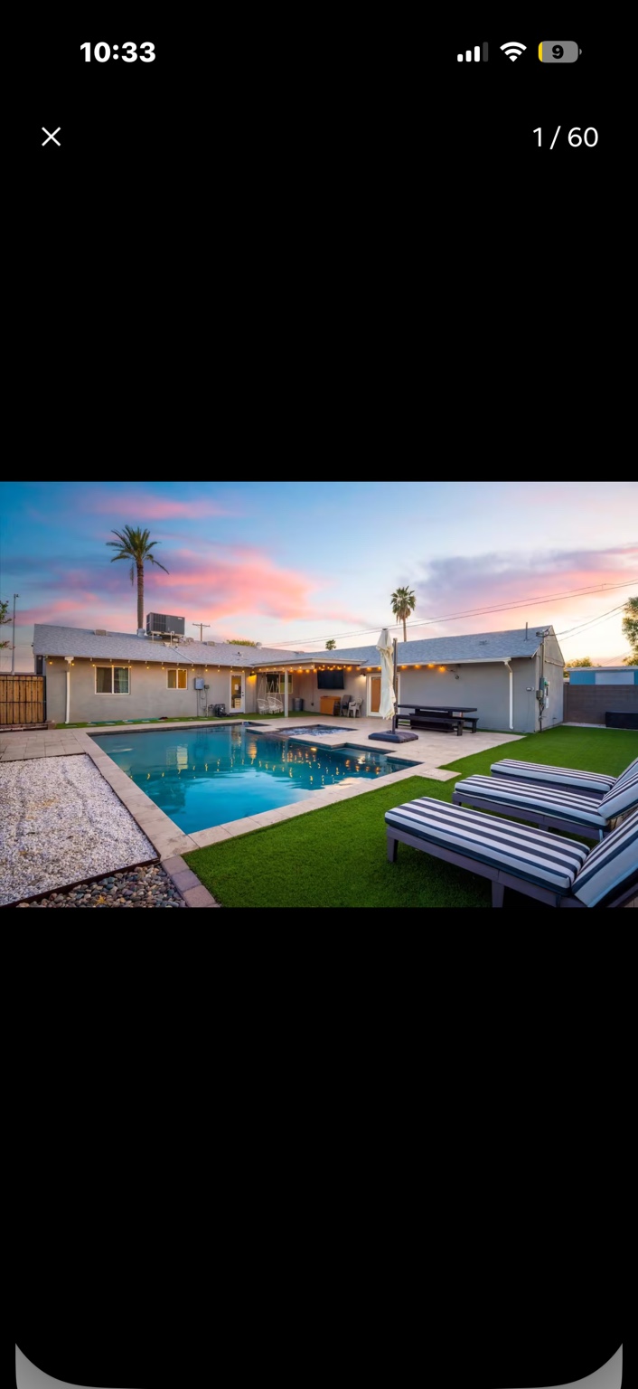 Heated backyard pool and lounge chairs at sunset